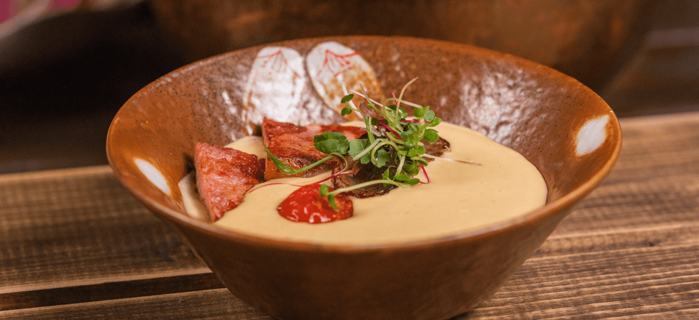 Чечевичный крем-суп с ломтиками ветчины и жареными томатами